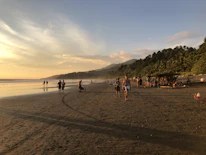 Happy travelers exploring a beautiful Indonesian beach during sunset.