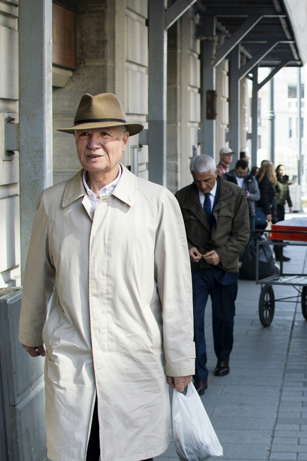 man in gray overcoat and brown hat