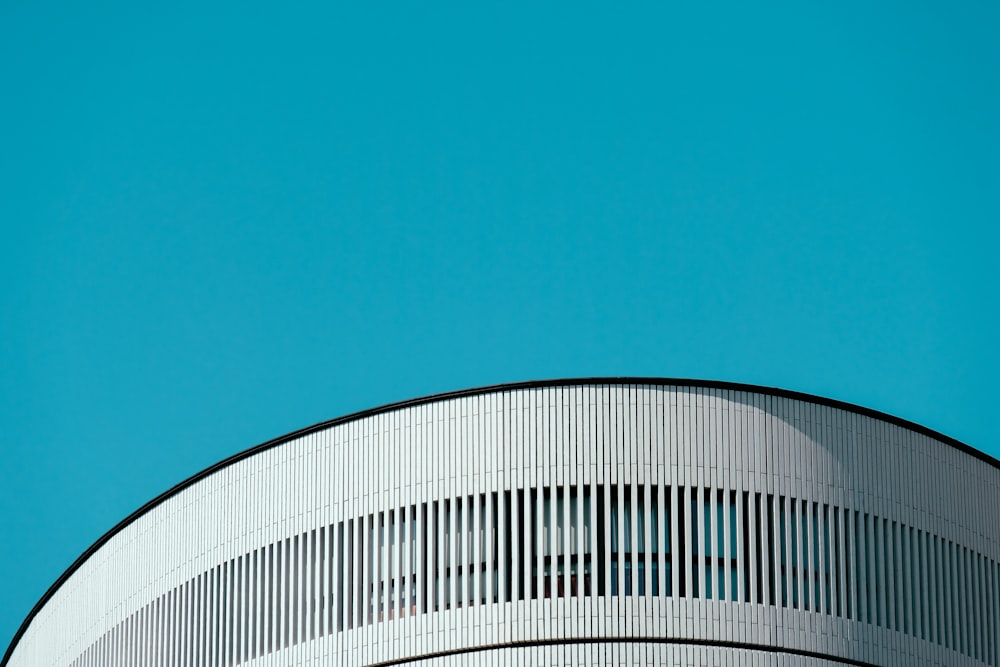 an airplane flying over a building with a blue sky in the background