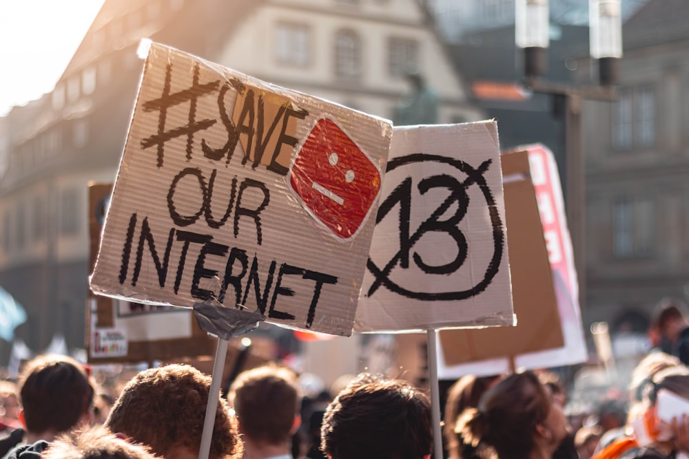 shallow focus photo of people holding signage