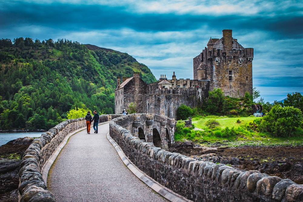 man and woman talking on gray concrete bridge