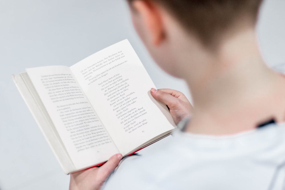 person in white holding book reading