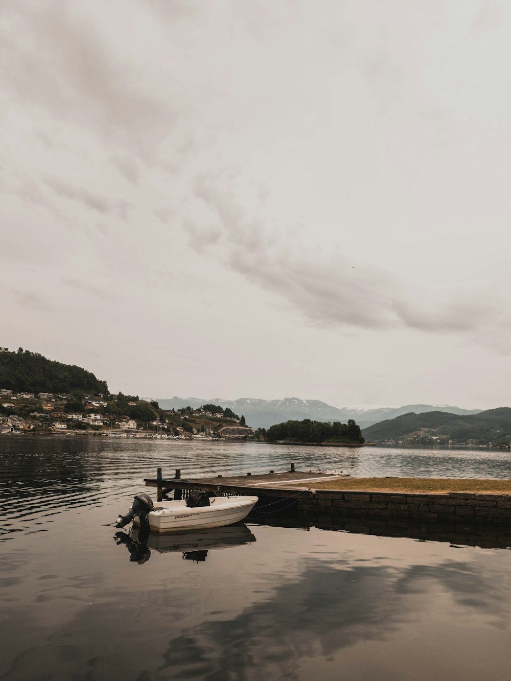 white boat beside brown dock