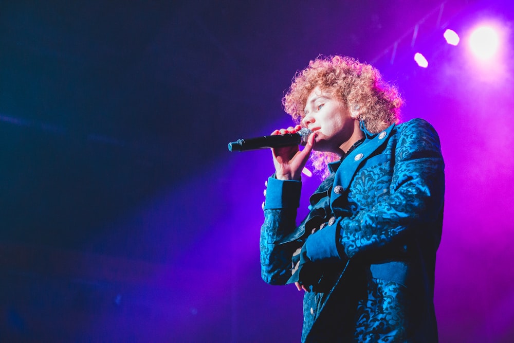 man in blue coat singing