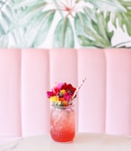 Vibrant pink rose and pomegranate lemonade served with fresh mint leaves and ice cubes in a mason jar.