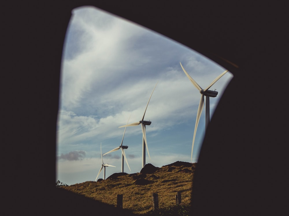 four gray windmills during daytime