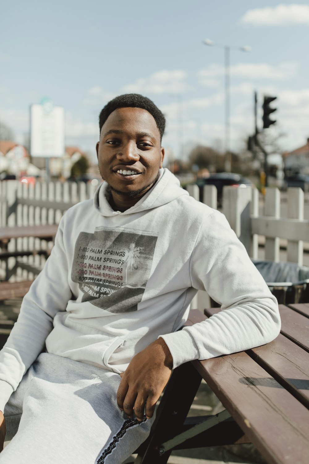 man wearing white pullover hoodie sitting on bencgh