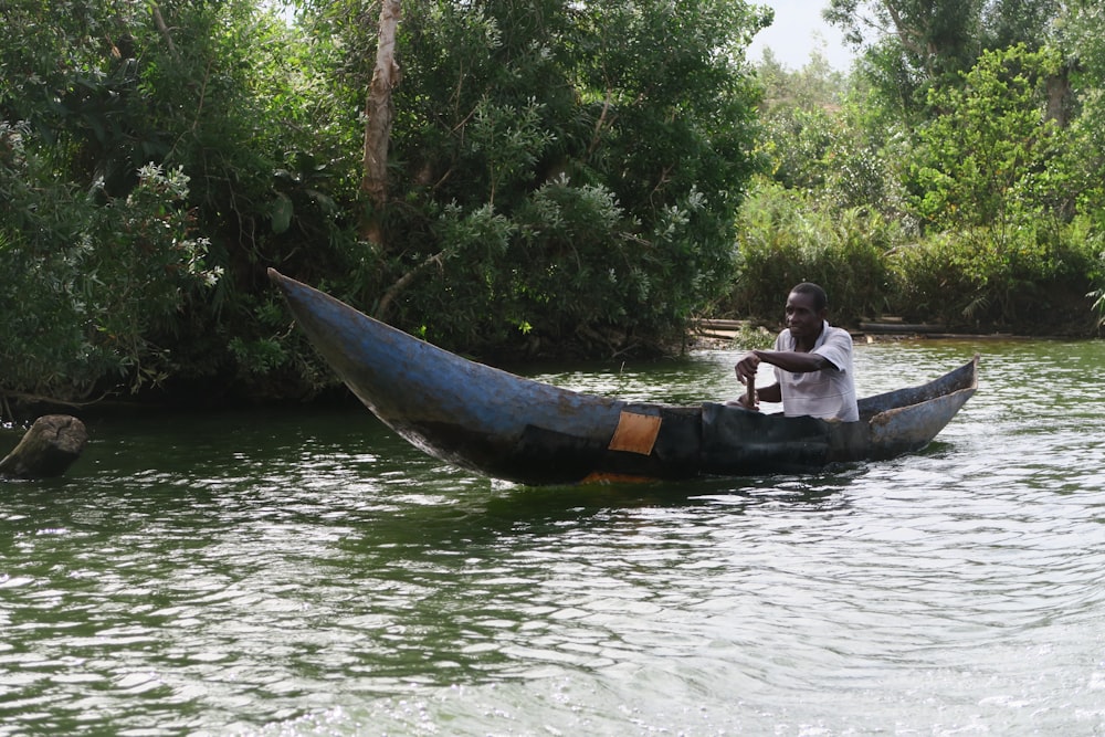 man riding on blue boat