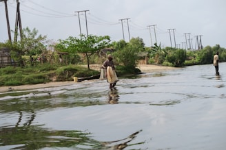 Vibrant image of a Nigerian village with clean water flowing from a newly installed Aqua Power pump.