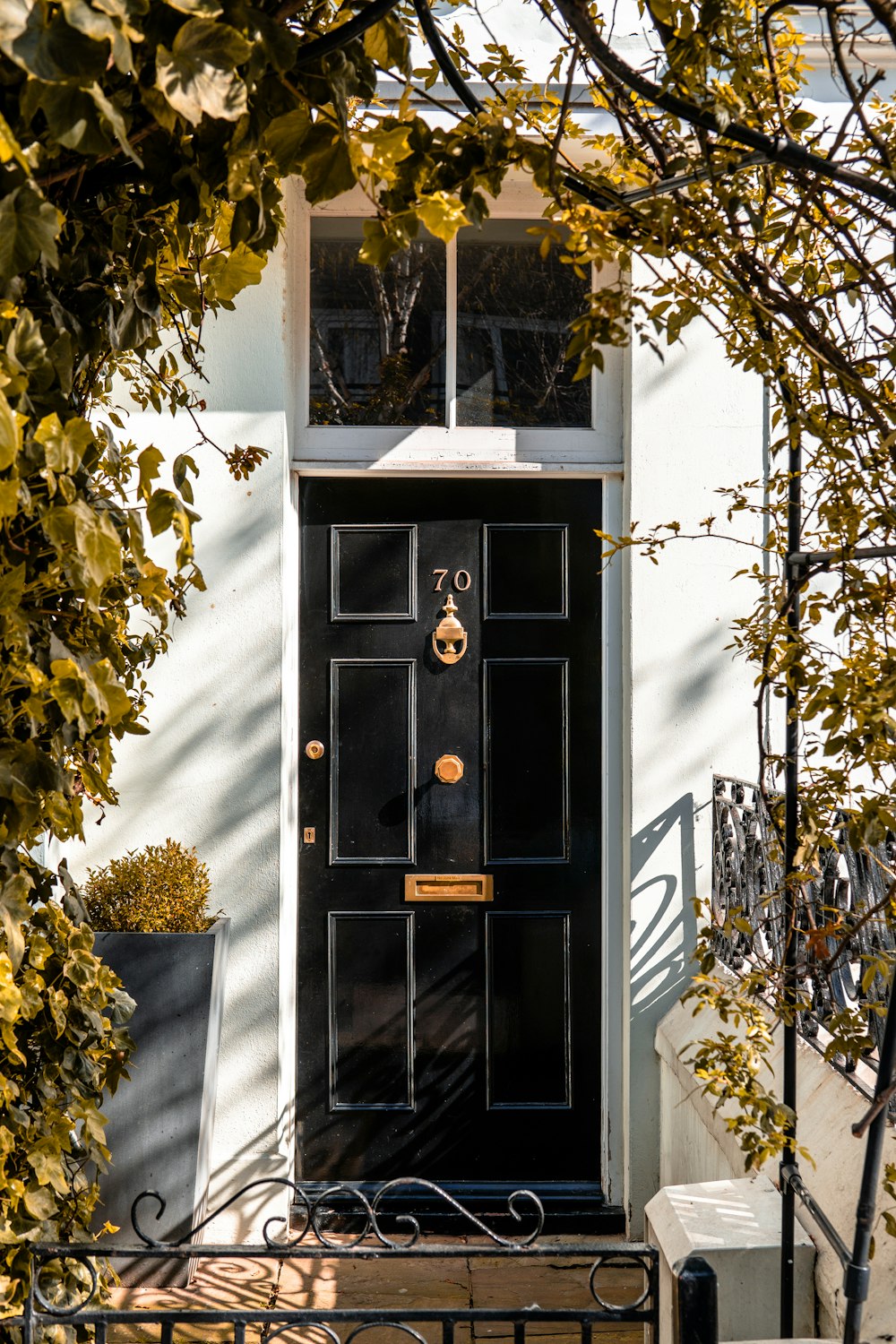 black door near arch door with plants during daytime
