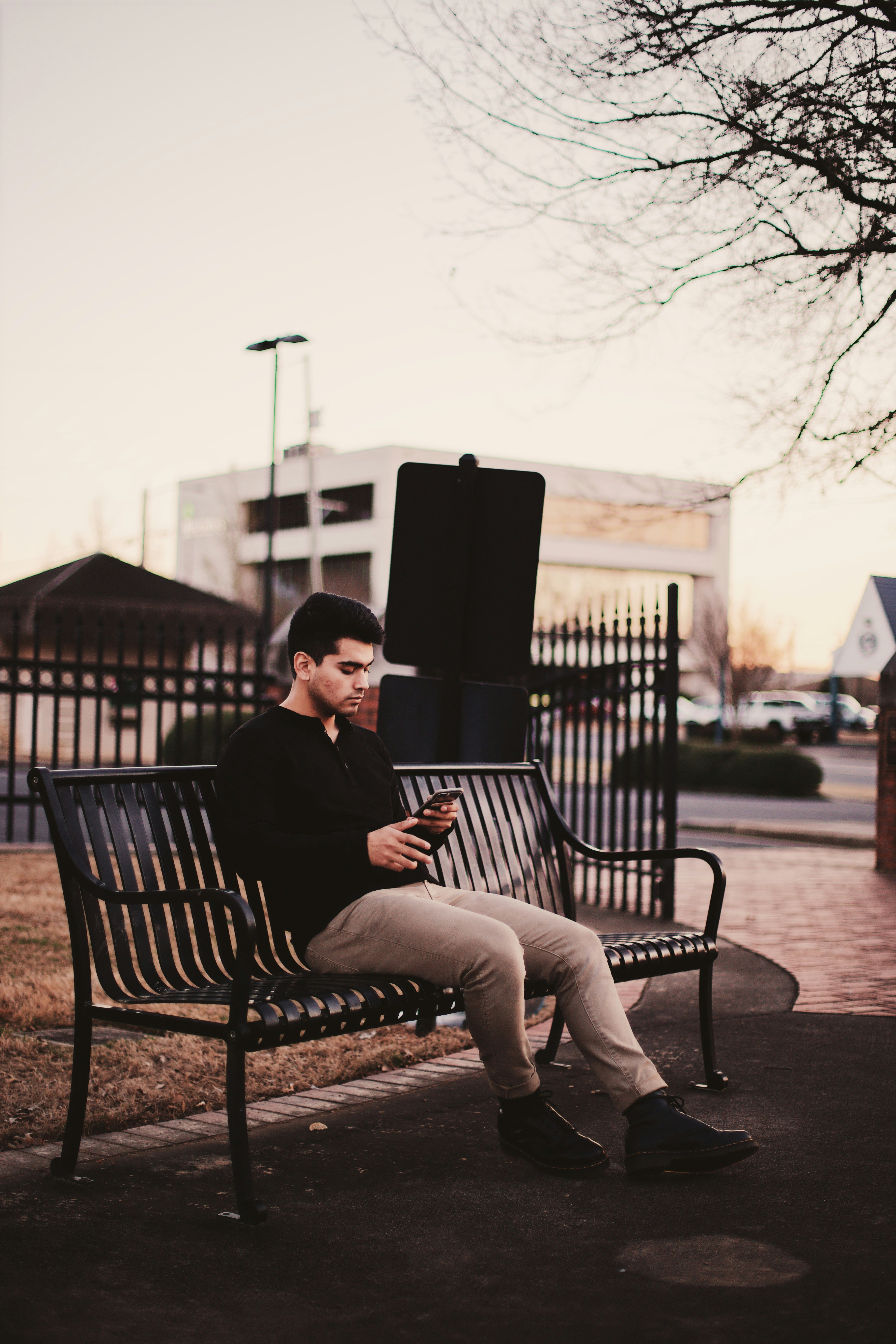 Man sitting on black bench under withered tree photo – Free Beige Image ...