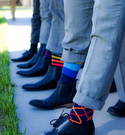 people showing black leather dress shoe lot outdoor during daytime