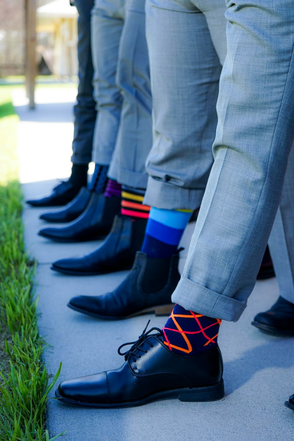 people showing black leather dress shoe lot outdoor during daytime