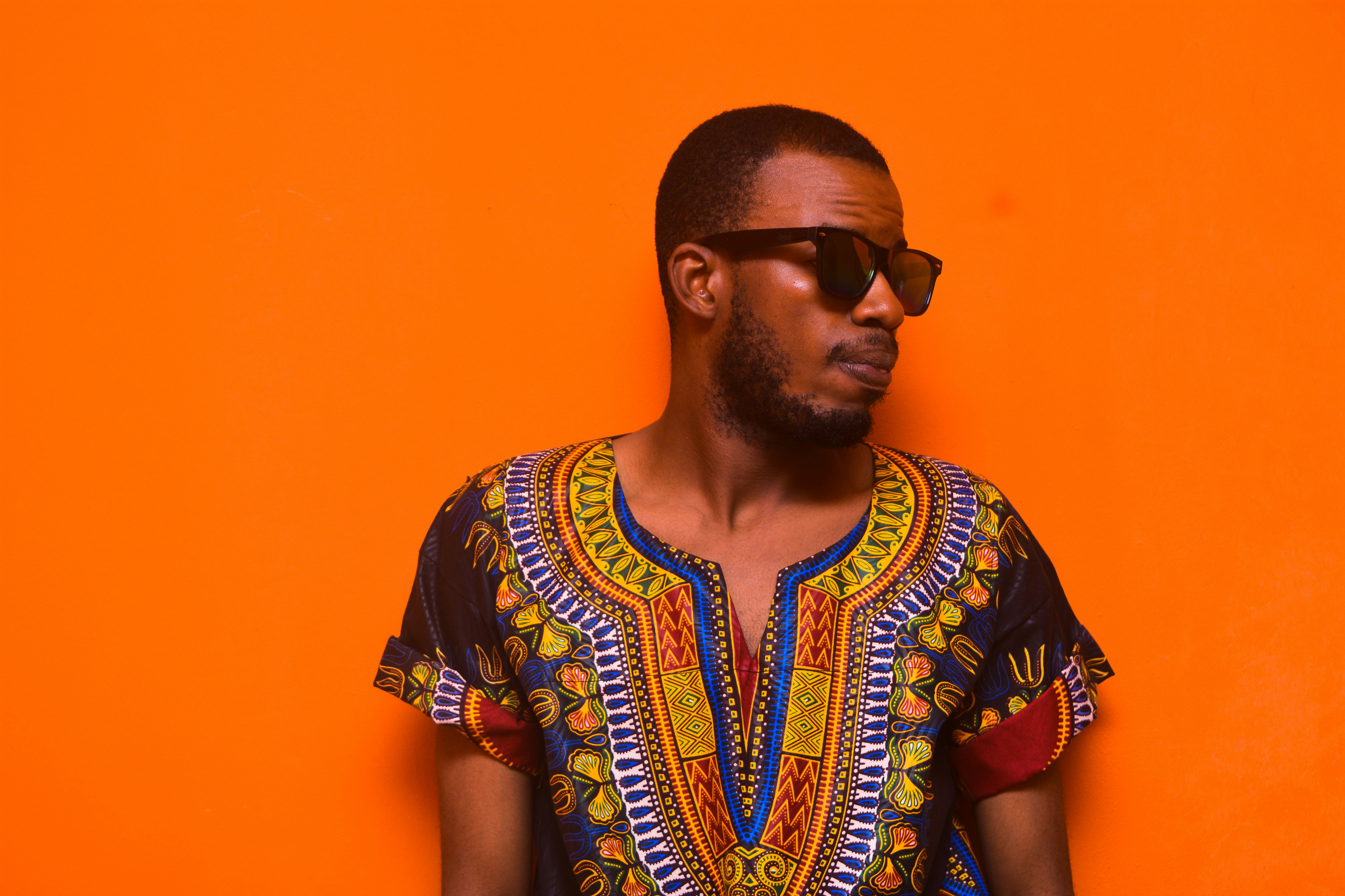 man wearing blue, orange, and red floral short-sleeved shirt