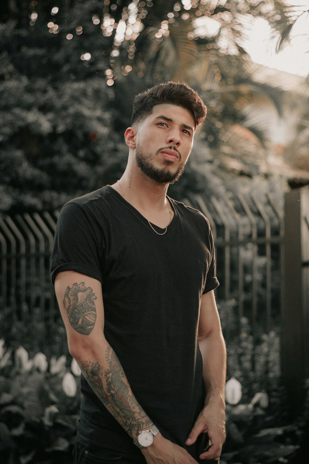 man standing near gray fence