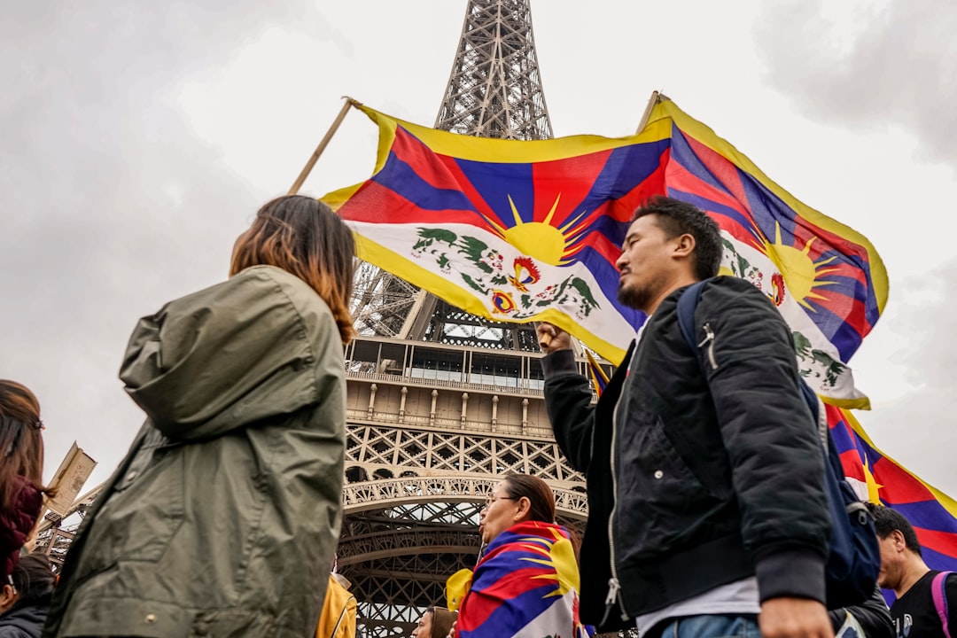 woman wearing gray jacket holding multicolored lflag