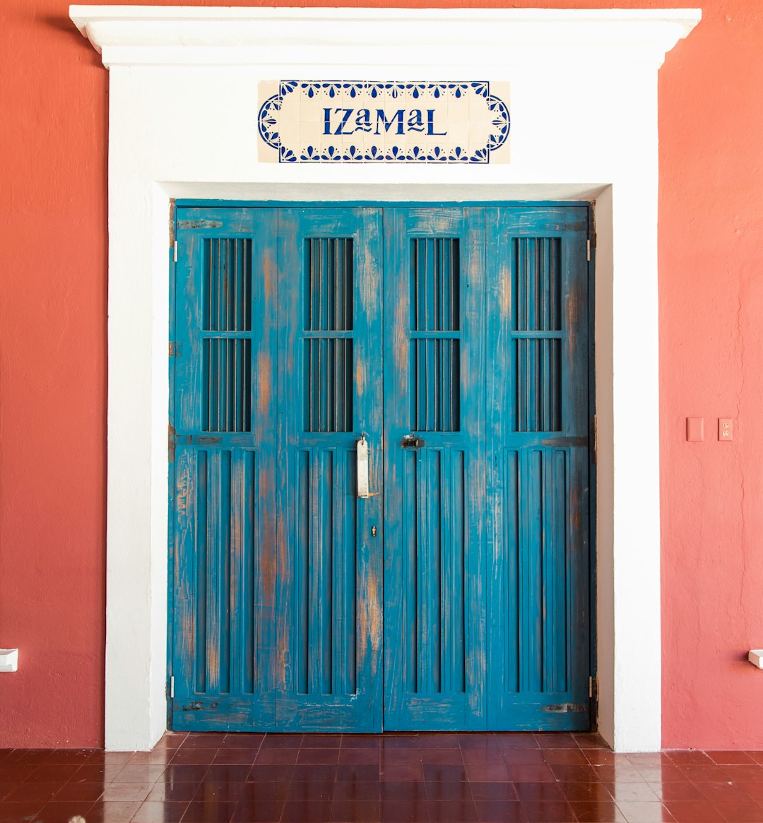 blue wooden door beside wall