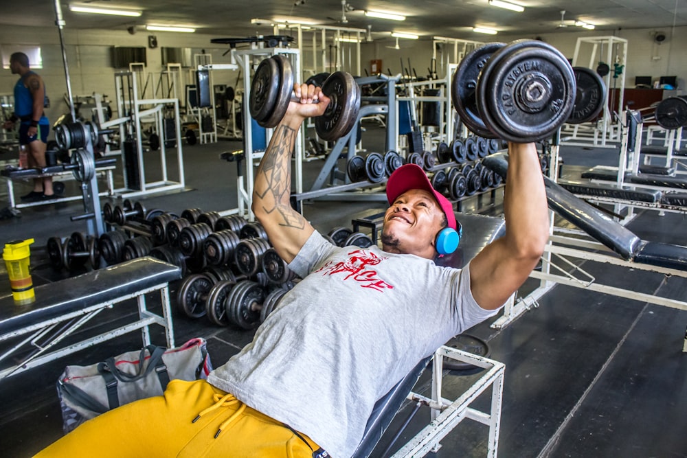 man lying on weight bench lifting to dumbbells