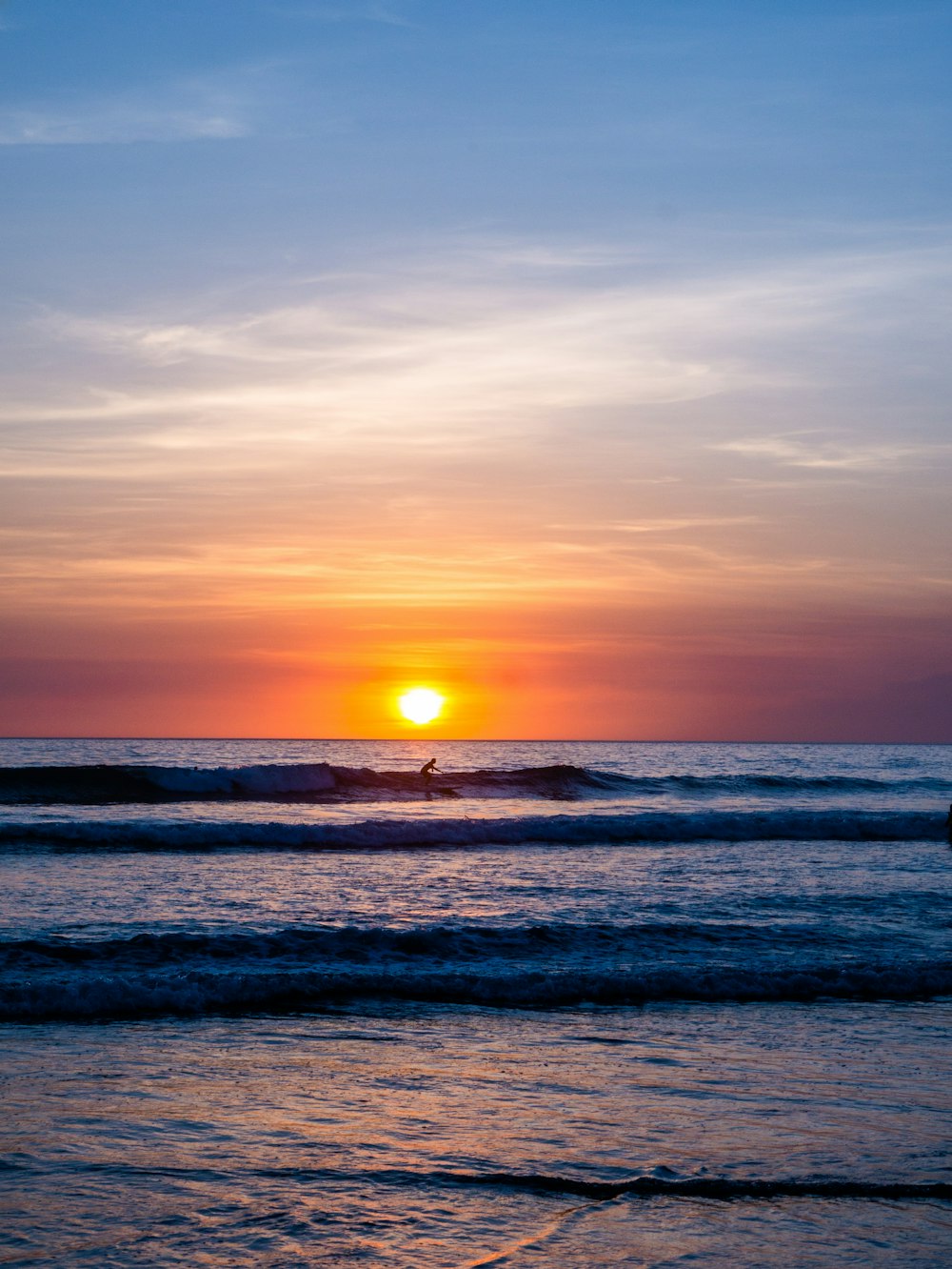 man riding surfboard in the middle of ocean