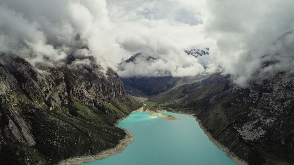 body of water in between mountains at daytime