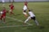 Dynamic shot of a female soccer player making a precise pass during a match.