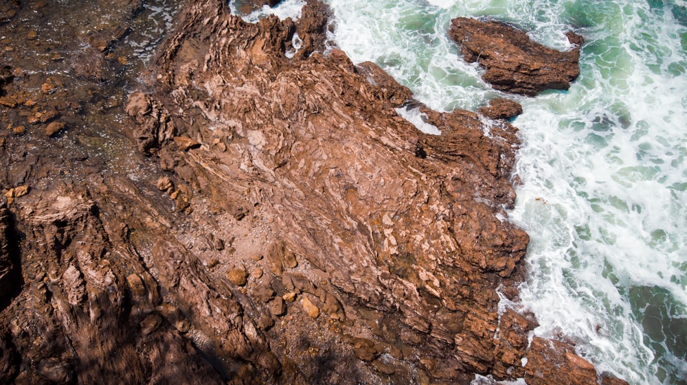 Photographie à vol d’oiseau d’un fragment de roche à côté d’un plan d’eau