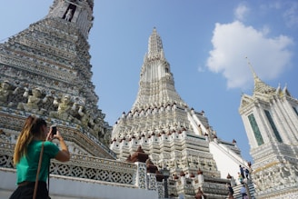 A user uploading photos and details of a serene Hindu temple on a laptop.