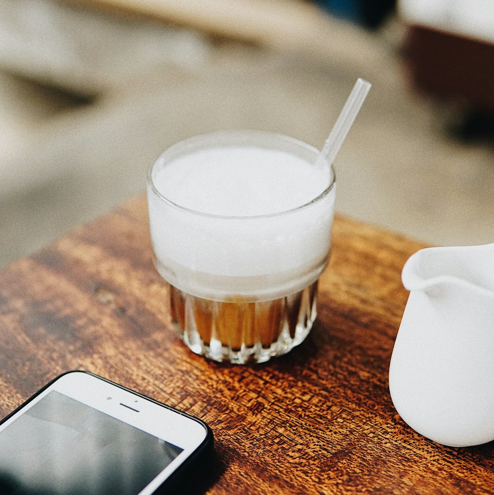 brown and white beverage in clear glass