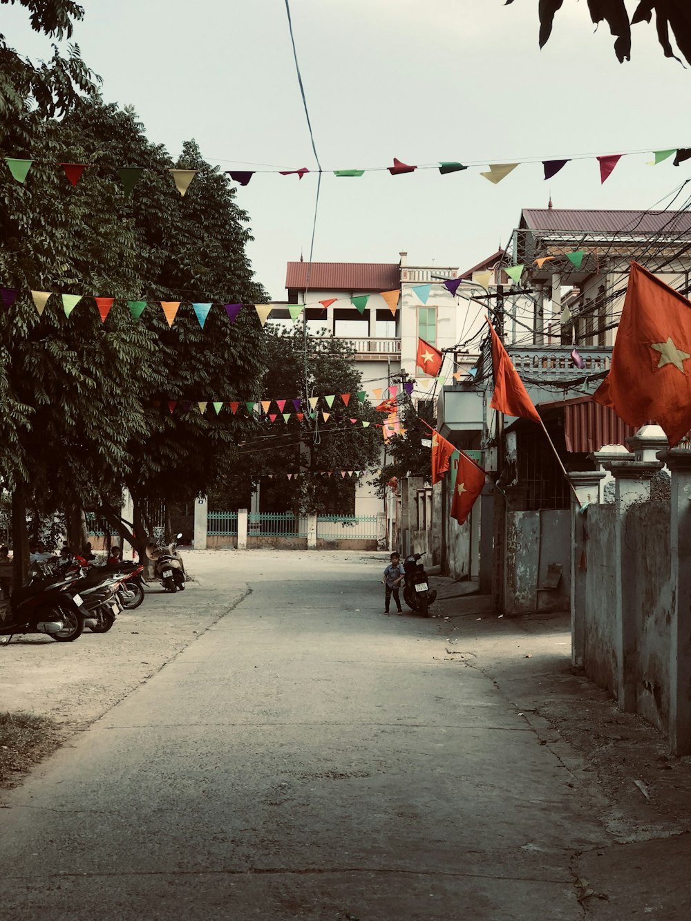 boy standing beside motor scooter in front of gate