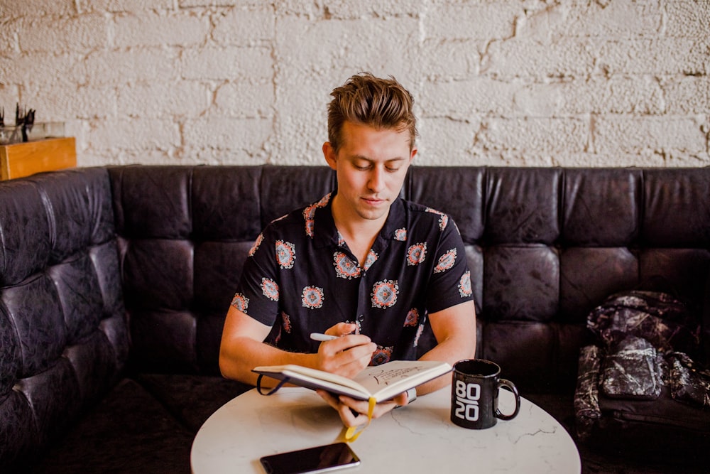 man sitting while holding an open book