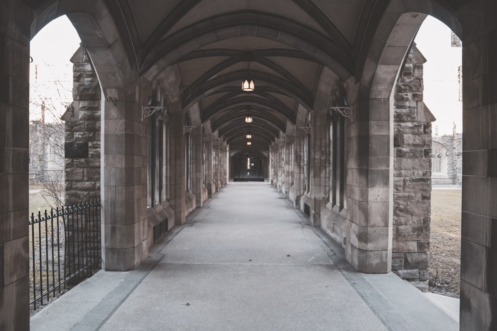 a walkway between two buildings with a clock on each of it's sides