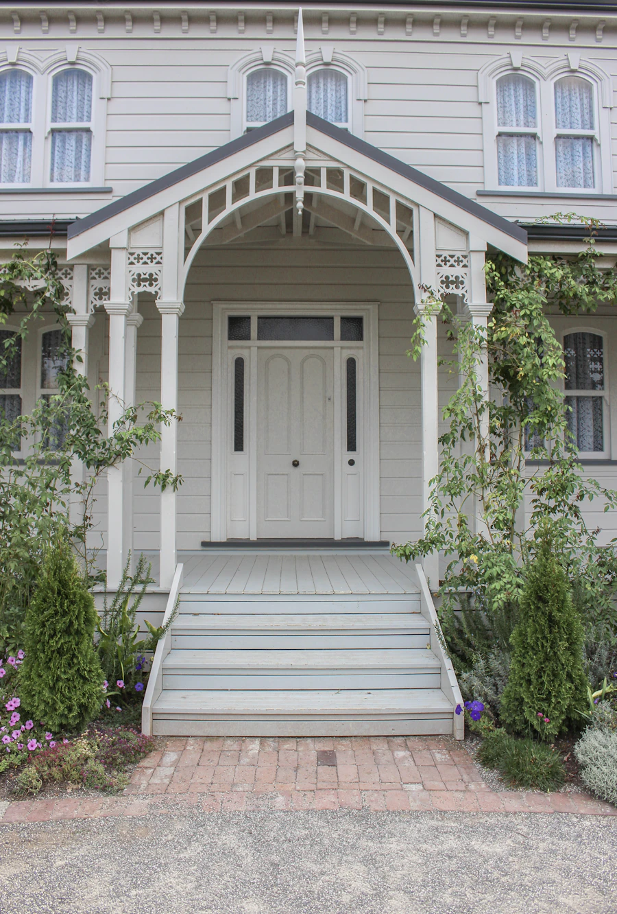 A white house with a black front door on a quiet residential street
