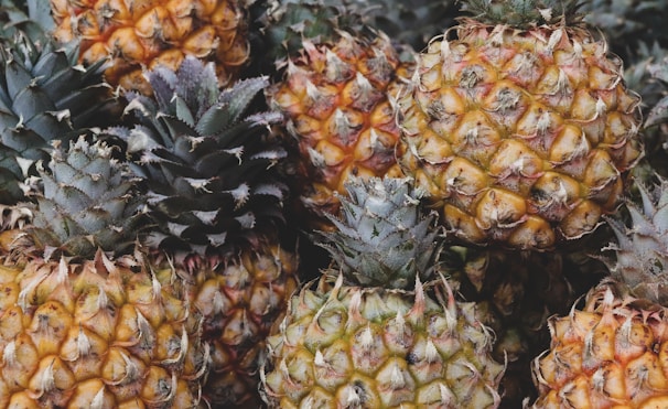 A close-up of juicy pineapples stacked for sale.