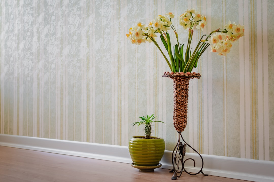 brown and black vase with yellow petaled flowers