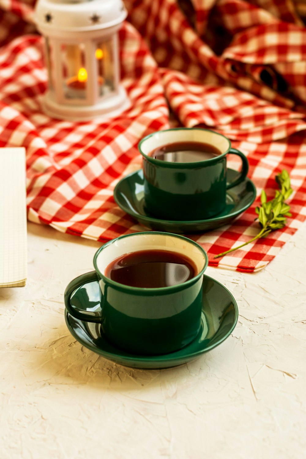 two coffee filled mugs on saucers