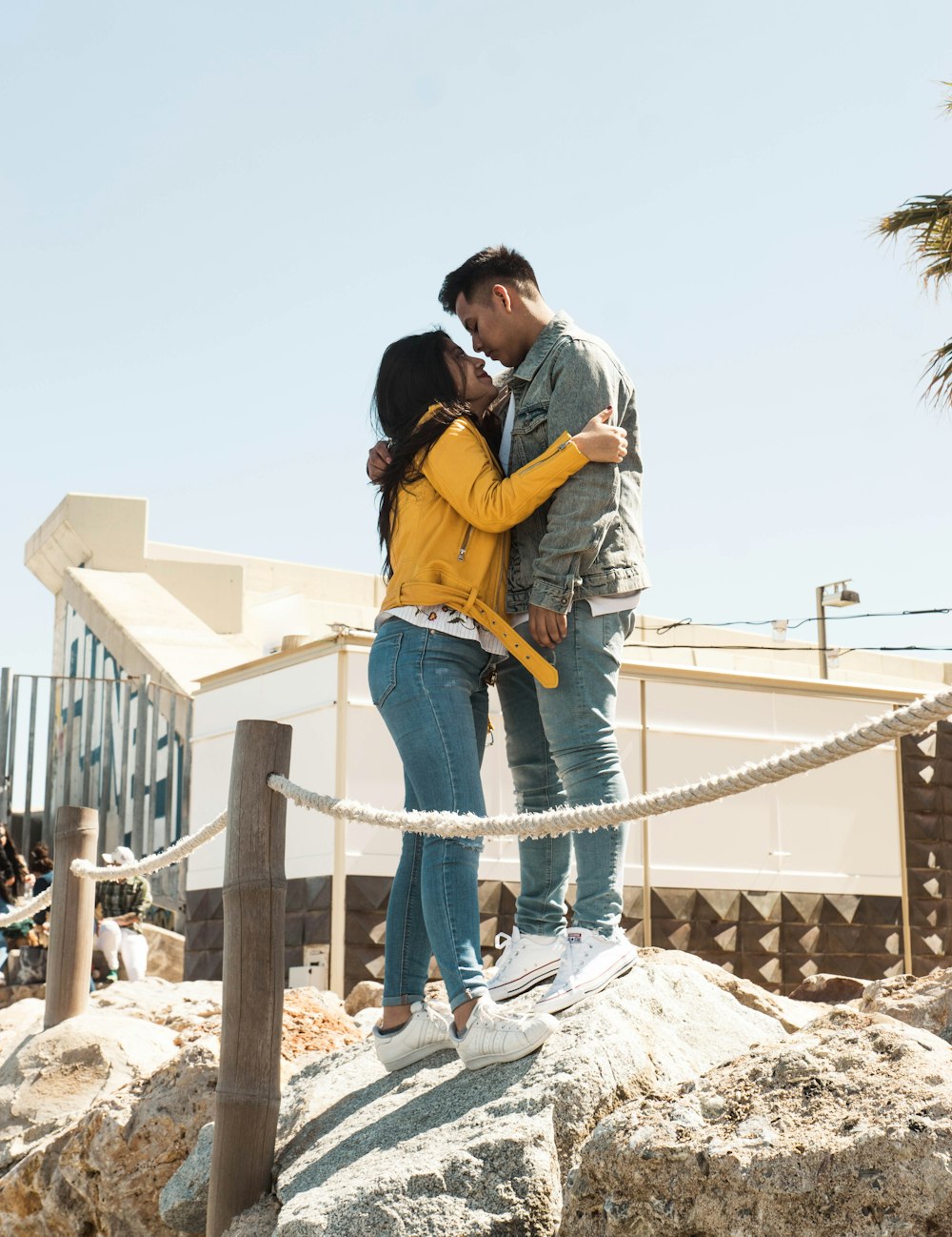 man and woman standing on rock during daytime