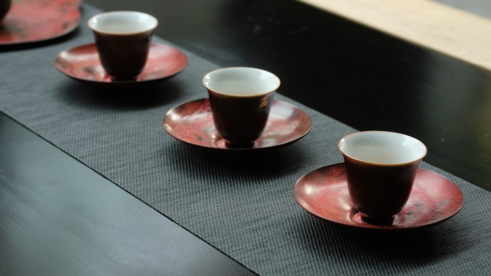 red ceramic cups and saucers