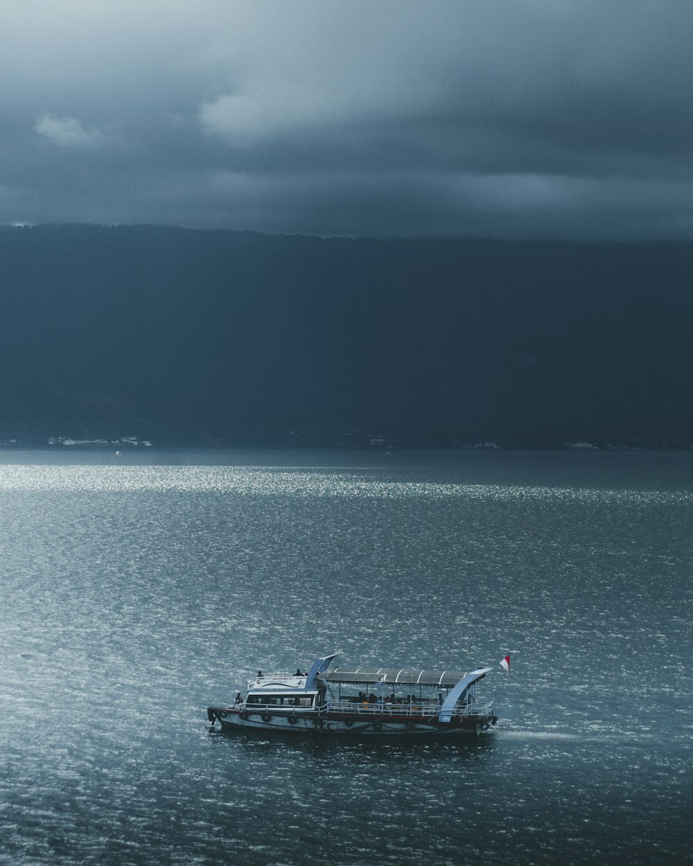 gray ship on body of water under cloudy sky