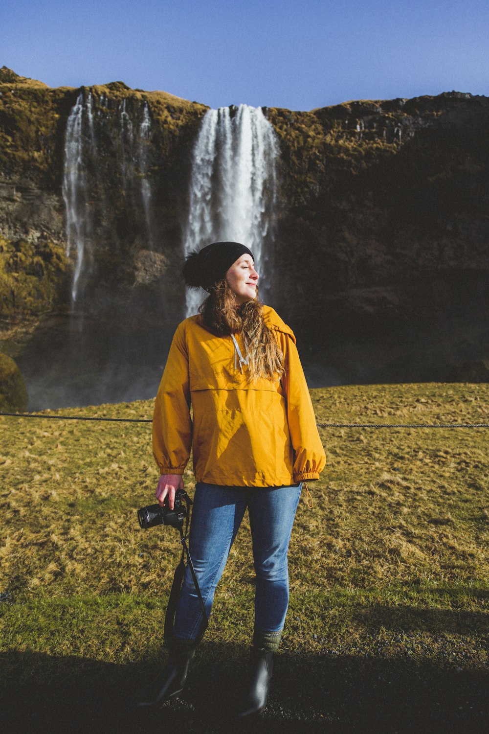 woman standing near waterfall