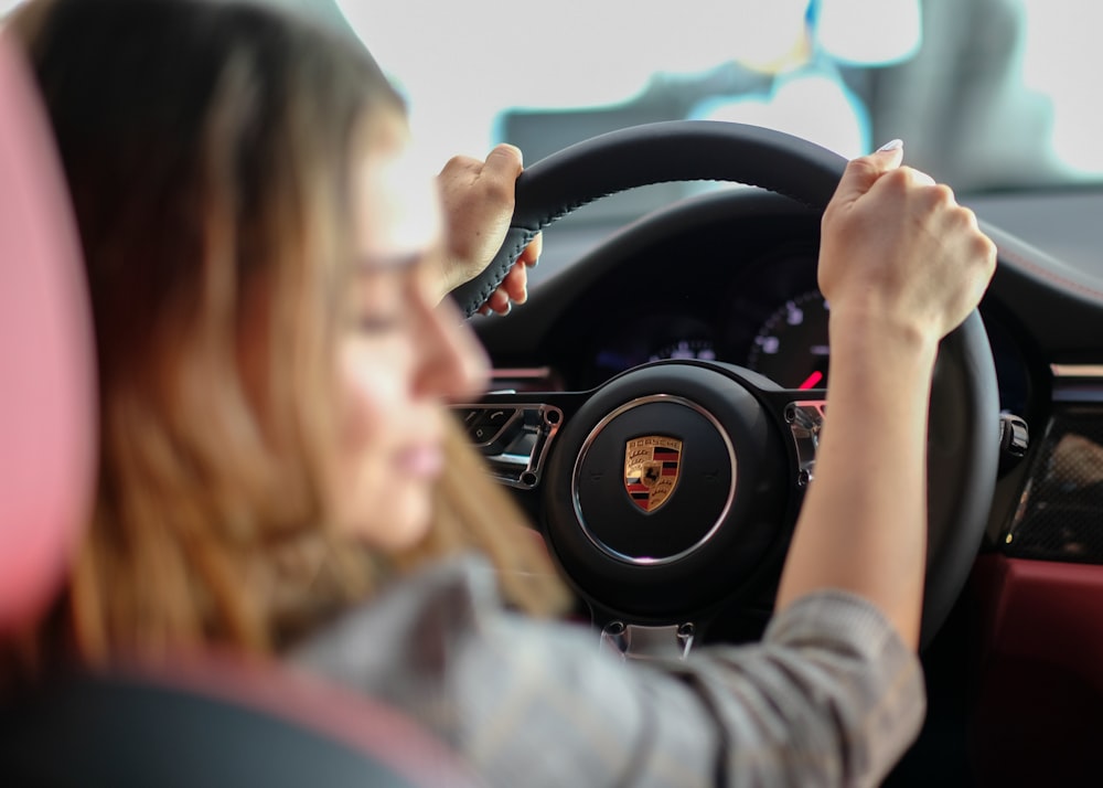 mujer conduciendo un vehículo Porsche