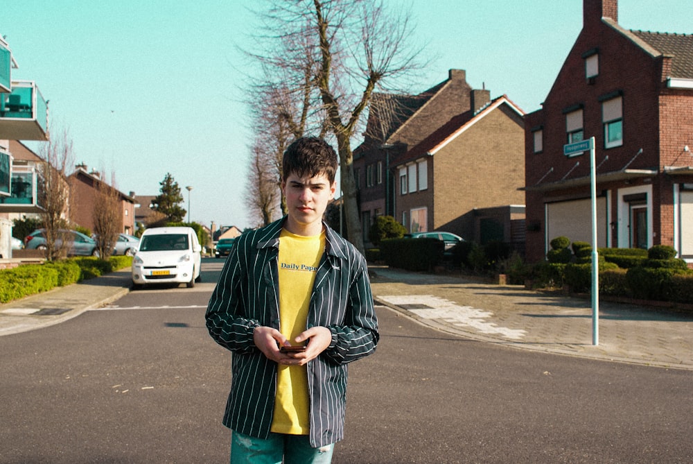 man standing on street near houses