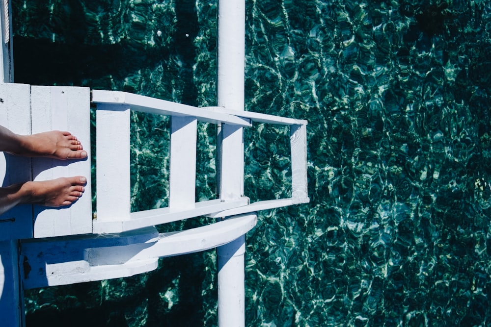 person standing on the step ladder of boat