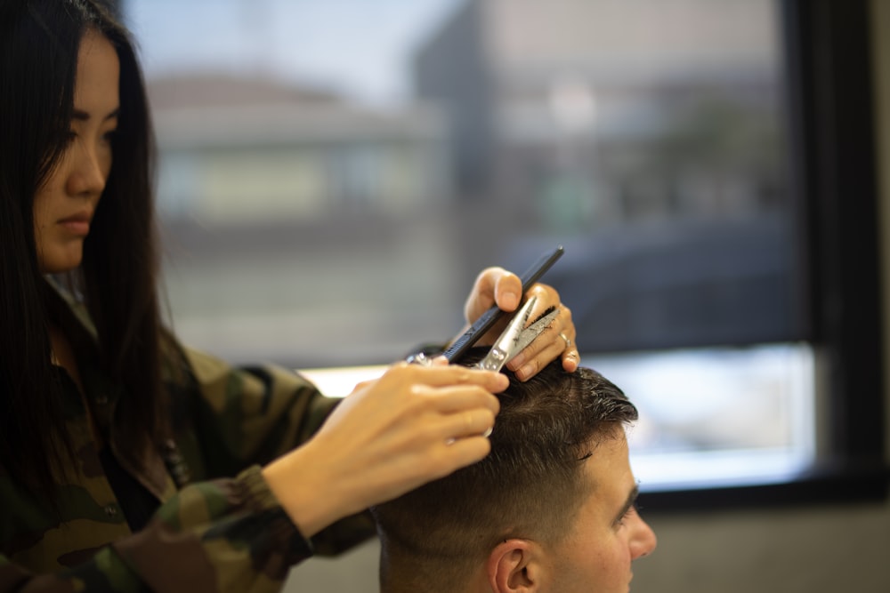 woman cutting mans hair close-up photography