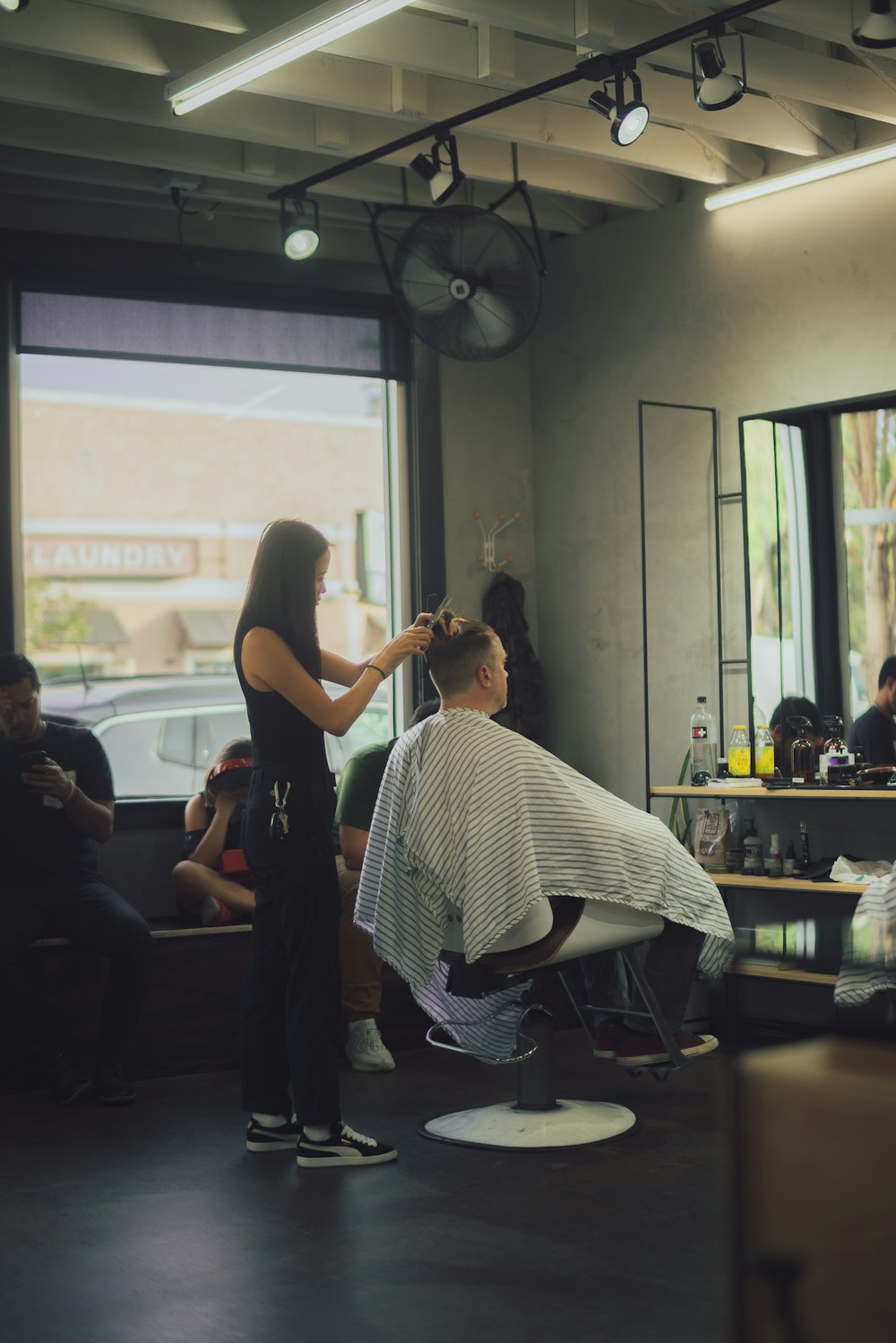 woman doing hair cut inside barber shop