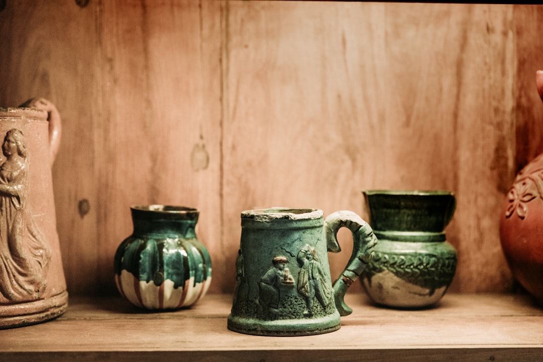 three assorted-color vases on brown surface