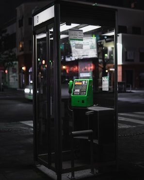 A serene phone booth with the Clairvoyance Premium logo glowing gently in the evening