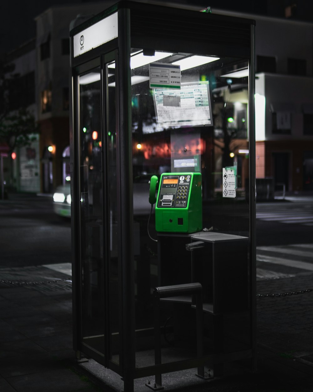 black and green telephone booth outdoor during nighttime