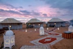 A luxurious desert camp set up under a starry night sky.
