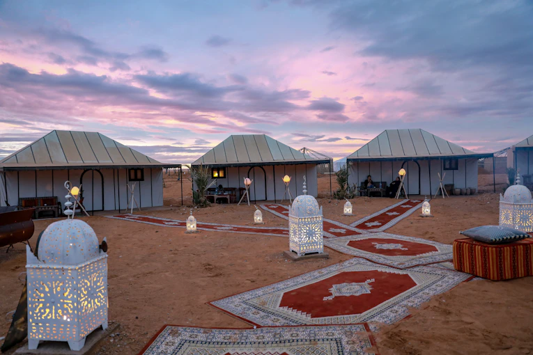 A serene desert camp under a starry night sky with traditional Berber tents.