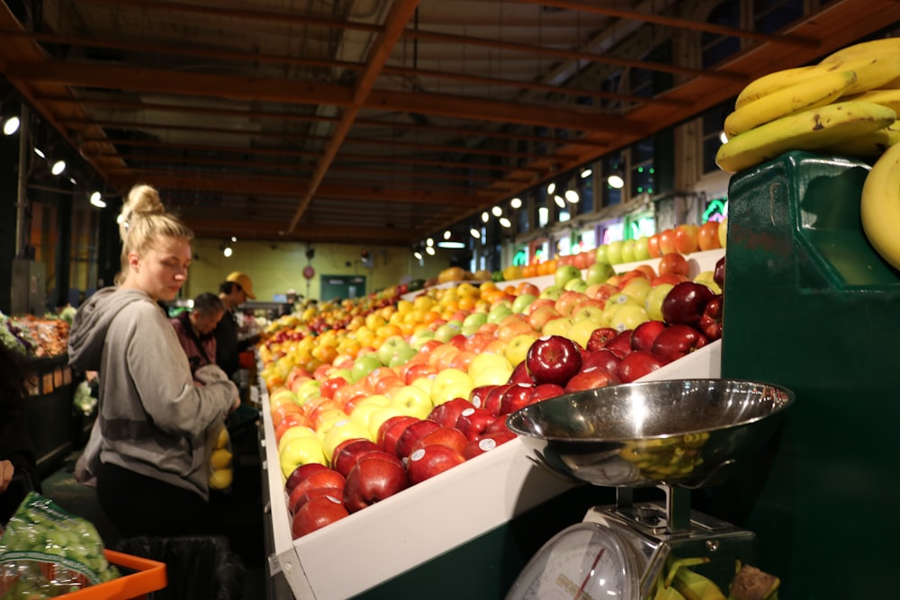 woman looking at displayed fruits